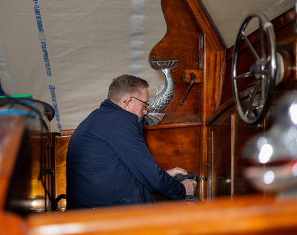 A man is refurbishing the Royal Barge at The Royal Yacht Britannia. 