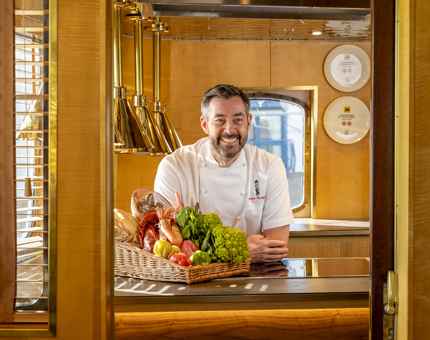 A Chef standing behind the counter in Fingal's Bridge Galley. 
