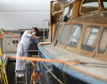A man sanding the Royal Barge. 