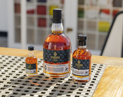 Three bottles of Edinburgh Rum in various sizes. 