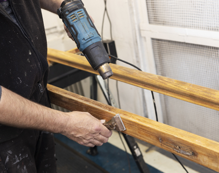 A Closer Look At Varnish Being Removed From Handrails with a heat gun