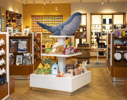 In Britannia's Shop, there is a tiered display unit with Jelly Cat plush toys on it, there is a very big blue whale toy at the top. 