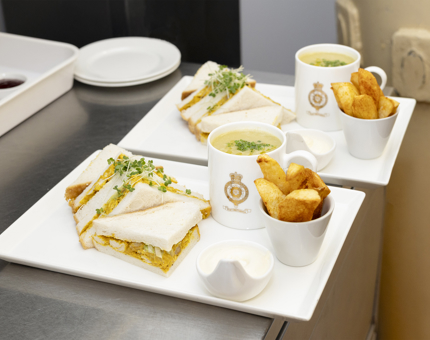 Two platters with soup, sandwiches and potato wedges in Britannia's Tearoom Galley, ready to be served. 