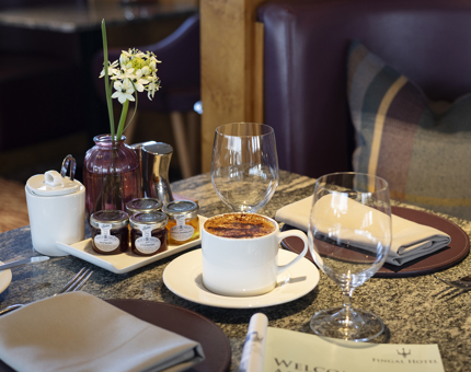 A close up of a table set for breakfast in the Lighthouse Restaurant in Leith. There is a cup of coffee and jams. 