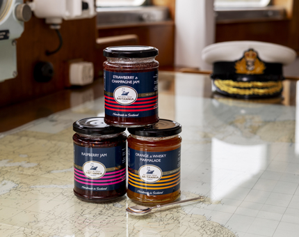 Three jars of jam stacked on top of each other, they have Britannia branded labels. 