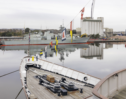 A view across the Port of Leith from Britannia's decks - there is a navy ship in the port. 