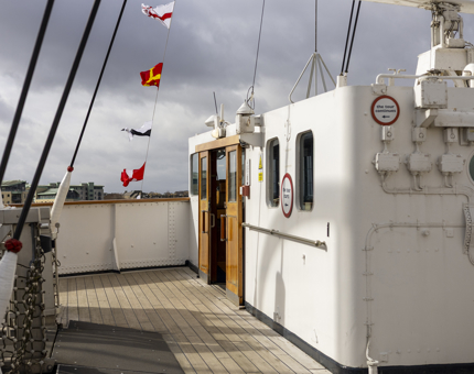 Colourful dress flags are flying over the Bridge aboard Britannia in the Port of Leith. 