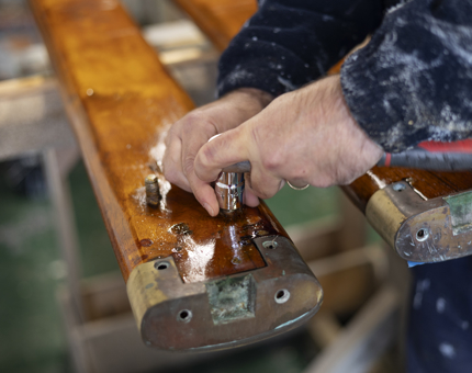 A close up of hands removing bolts from a handrail. 