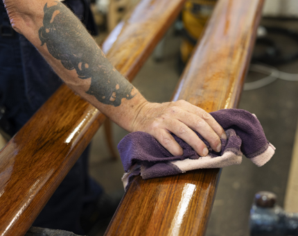 A close up of a hand holding a cloth to wipe down a handrail. 