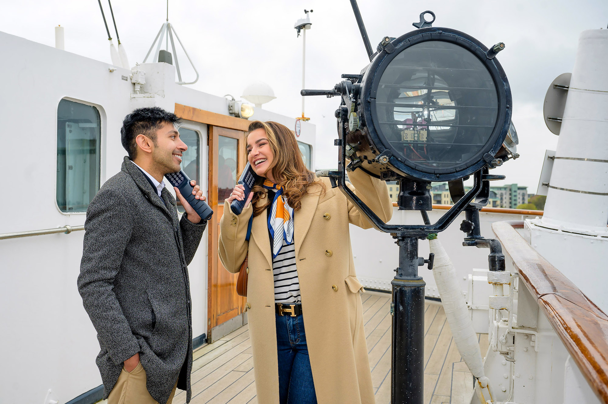 Couple listening to handsets as they tour a ship