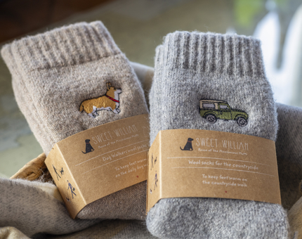 Two pairs of wool socks. One had a dog embroidered on it, the other, a car. 