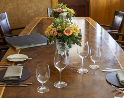 The table in Fingal's Bridge is set for a meal. There are vases with colourful flowers in them. 