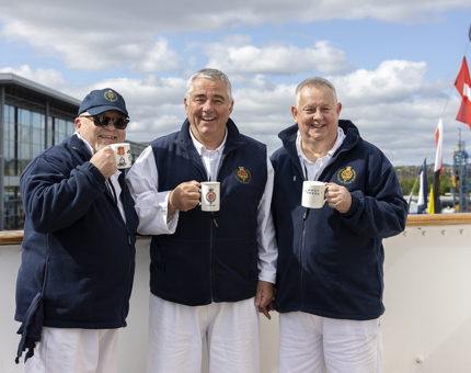 Three Yotties holding Britannia branded mugs.