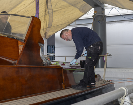 A Maintenance man standing on the Royal Barge, adding a layer of paint.