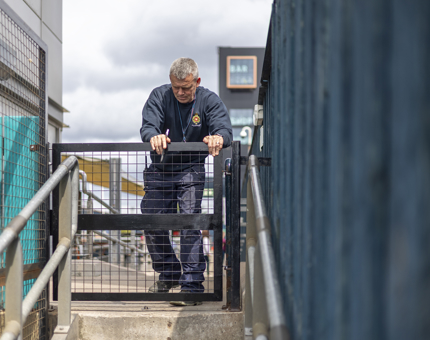 A Maintenance team member fixing a metal gate. 