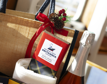 A chocolate bar and wine bottle in front of a hamper