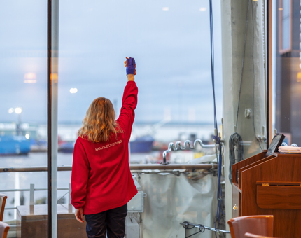 Housekeeper, Lynne, polishing windows in Tearoom
