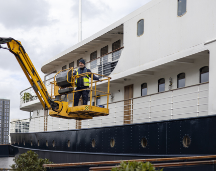 A man on a yellow cherry picker outside Fingal Hotel in Leith. 