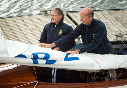 a woman and a man in a sailboat preparing to sail 