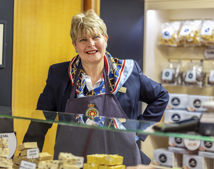 Onboard confectioner, Poppy stands behind the counter in the NAAFI, there are bars of fudge under the glass counter. 
