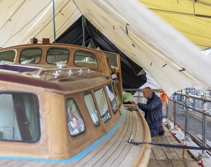 A Maintenance team member is refurbishing the Royal Barge at The Royal Yacht Britannia in Leith. 