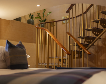 A view of a spiral staircase from the bed in a Duplex Suite aboard Fingal Hotel. 