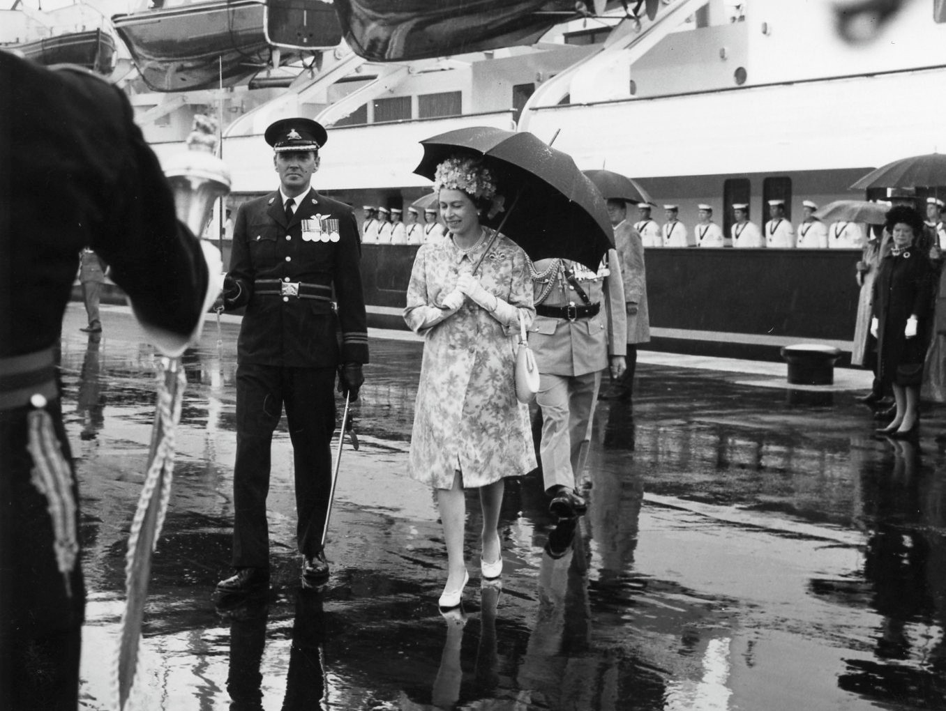 Queen Elizabeth II With An Umbrella Walking Off Britannia