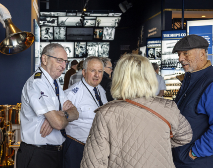 Two Yotties chatting to visitors in Britannia's Visitor Centre.