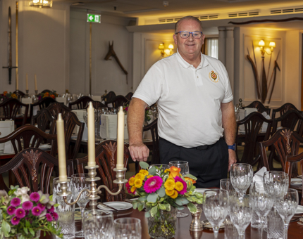 A Yottie is standing in the State Dining Room which is set for a dinner. 