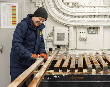 A maintenance team member sanding handrails. 