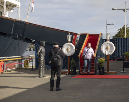A man taking and photo of a woman on the Royal Brow at The Royal Yacht Britannia in Leith. 