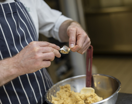 A close up of a chef making mackerel quenelles. 