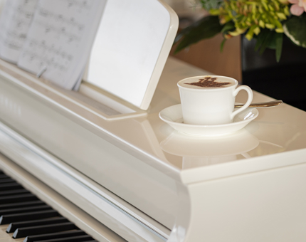 Cappuccino with a chocolate ship stencil sitting on the Tearoom's piano