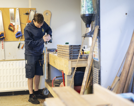 A Maintenance man is in the workshop Removing Screws From A Section Of Steps From Onboard Britannia. 