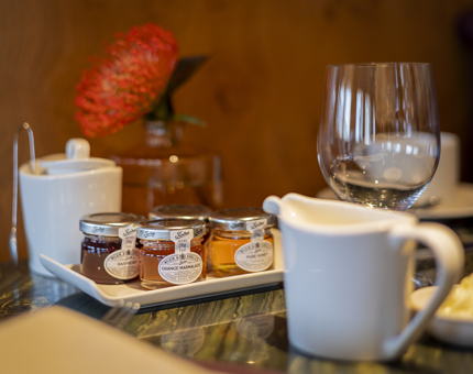 A breakfast table setting at The Lighthouse Restaurant aboard Fingal Hotel. There is a tray with jams, honeys and marmalades on it. 