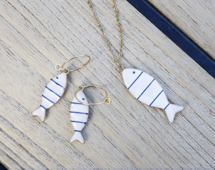 A set of blue and white fish earrings and a necklace. 