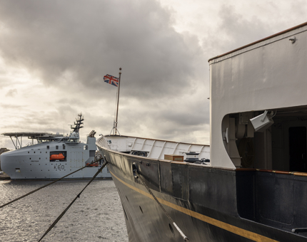 A view from Britannia of a big grey ship in the Port of Leith. 