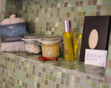 On a shelf in a shower Ishga spa products are lined up. 