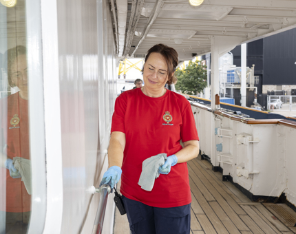 A Housekeeper is Polishing The Brass Hadrails On The Tour Route aboard Britannia. 